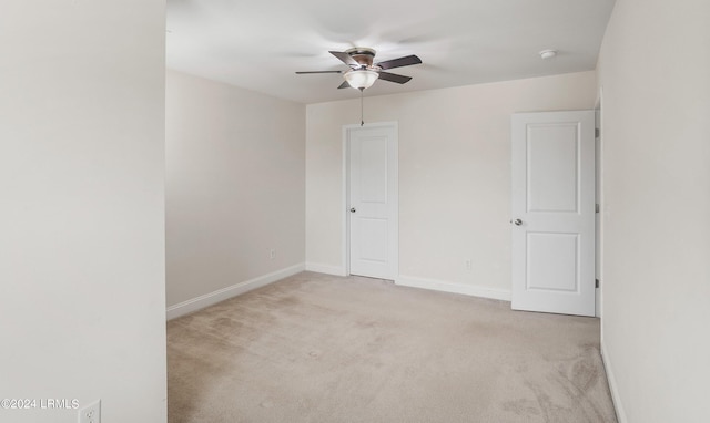 spare room featuring light colored carpet and ceiling fan