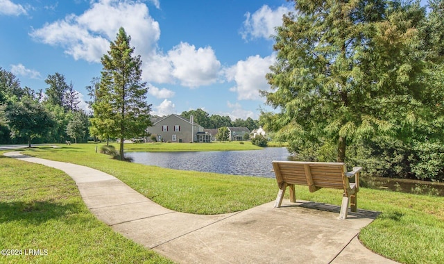 view of home's community with a water view and a lawn