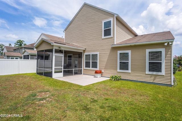 rear view of house featuring a yard, a sunroom, and a patio