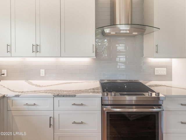2065 Deer Island Rd, Hilton Head Island, SC 29928 - kitchen featuring stainless steel range with electric cooktop, wall chimney exhaust hood, white cabinetry, and decorative backsplash