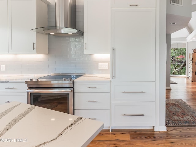 2065 Deer Island Rd, Hilton Head Island, SC 29928 - kitchen with wall chimney exhaust hood, stainless steel electric stove, light wood finished floors, and white cabinets