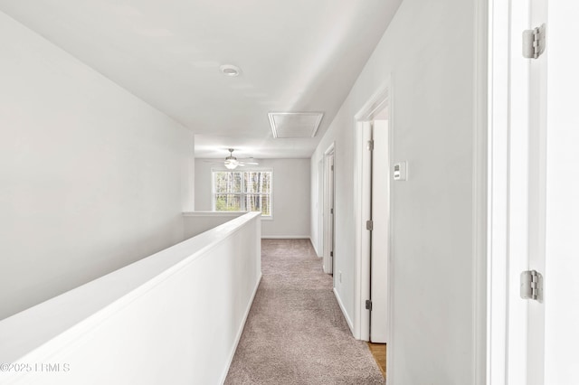 hallway featuring baseboards, light colored carpet, and an upstairs landing