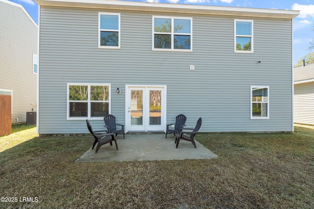 back of property with central AC, a patio, and a lawn