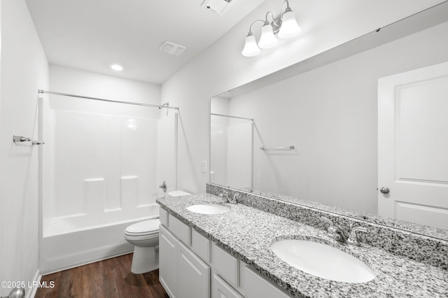 bathroom with visible vents, a sink, toilet, and wood finished floors