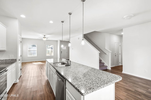 kitchen with appliances with stainless steel finishes, open floor plan, dark wood-type flooring, and a sink