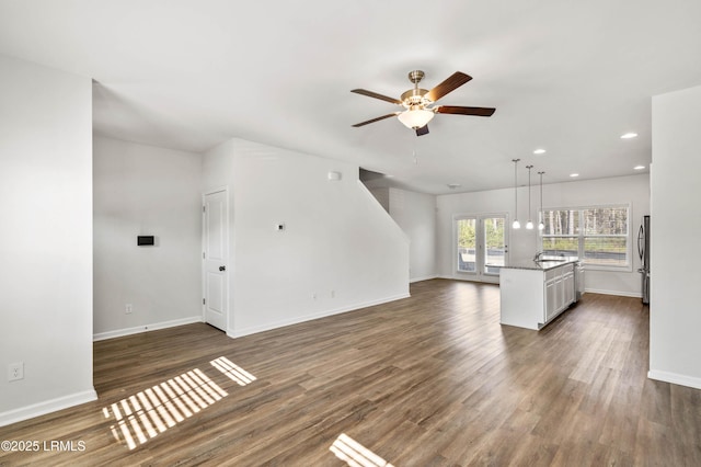 unfurnished living room featuring dark wood-style floors, baseboards, and recessed lighting