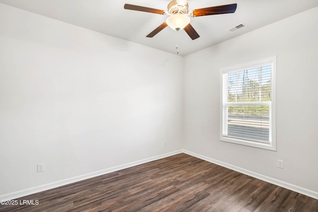 unfurnished room featuring dark wood-style floors, baseboards, visible vents, and ceiling fan