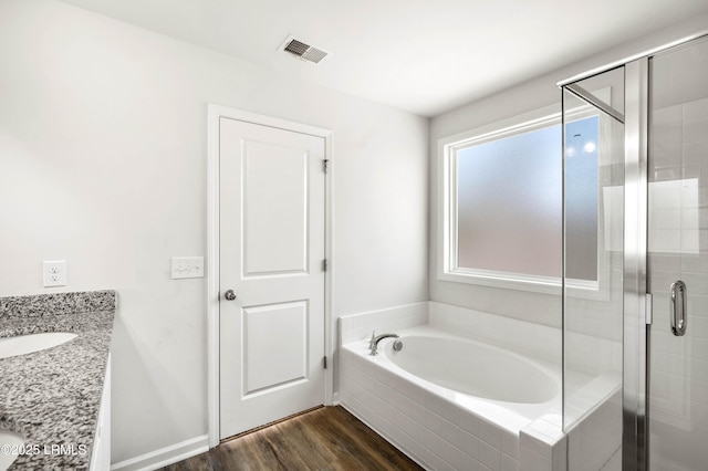 bathroom with visible vents, a garden tub, a shower stall, and wood finished floors