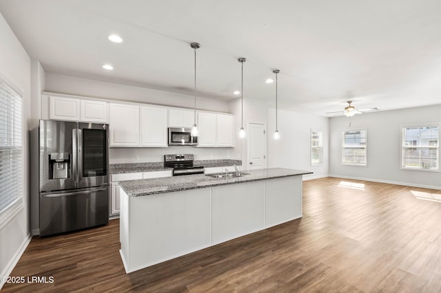 kitchen with stainless steel appliances, dark wood finished floors, white cabinetry, and a sink