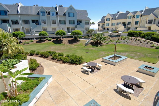 surrounding community with a lawn, an outdoor fire pit, a patio area, and a residential view