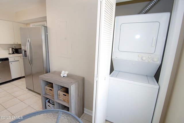laundry area with laundry area, stacked washer and dryer, and light tile patterned flooring