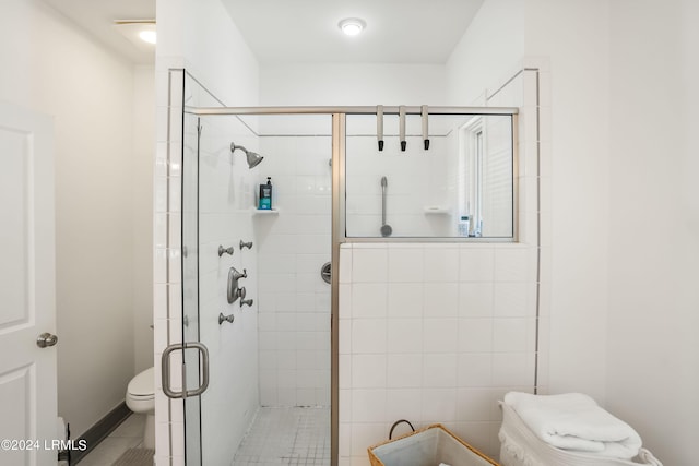 bathroom with toilet and a shower with shower door