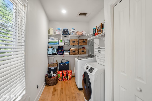 laundry area featuring hardwood / wood-style flooring and washing machine and dryer