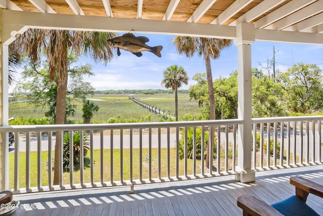 wooden deck with a lawn and a rural view