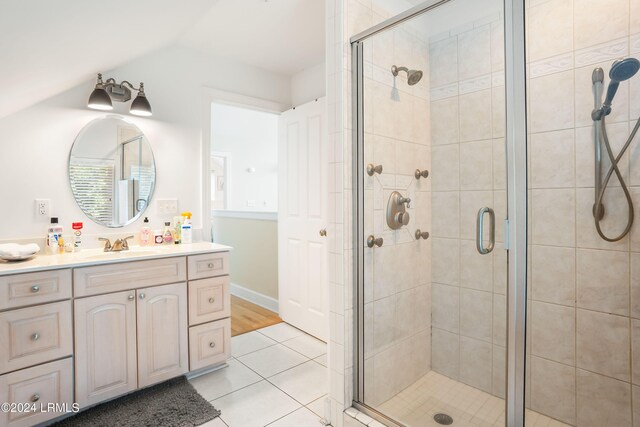 bathroom with vaulted ceiling, vanity, an enclosed shower, and tile patterned flooring