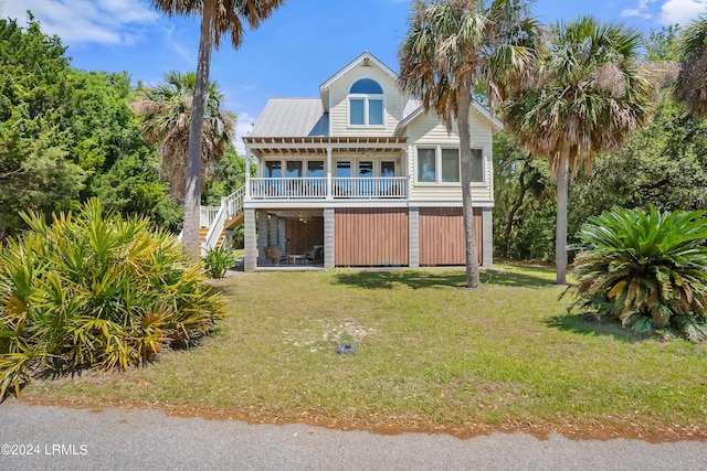 back of property featuring covered porch and a lawn