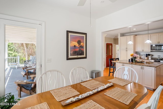 dining space with light hardwood / wood-style flooring and ceiling fan