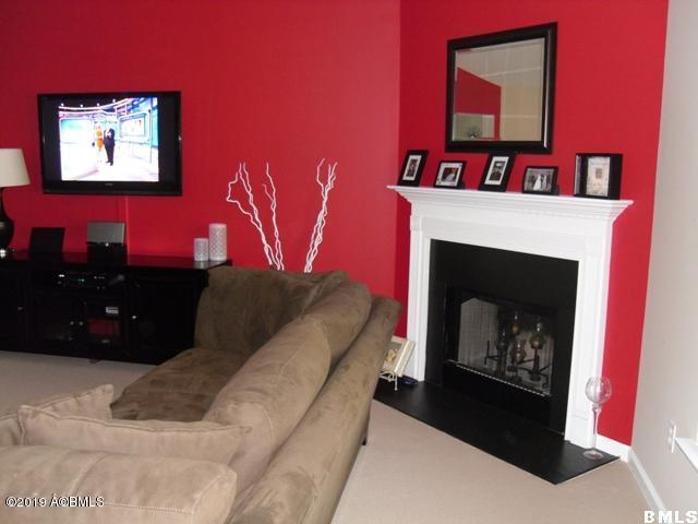 living area featuring carpet floors, baseboards, and a fireplace