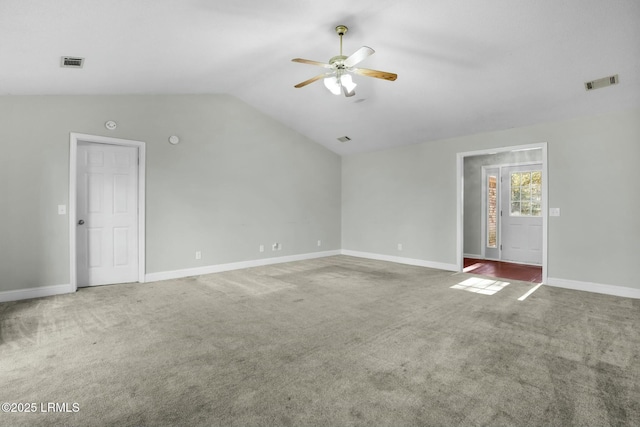 carpeted empty room with vaulted ceiling, ceiling fan, visible vents, and baseboards