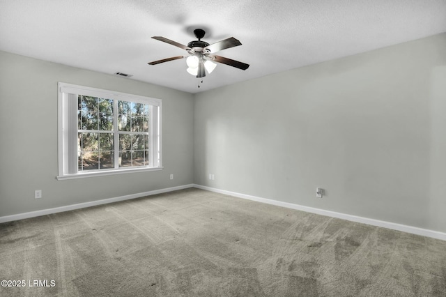 empty room featuring visible vents, light carpet, ceiling fan, a textured ceiling, and baseboards