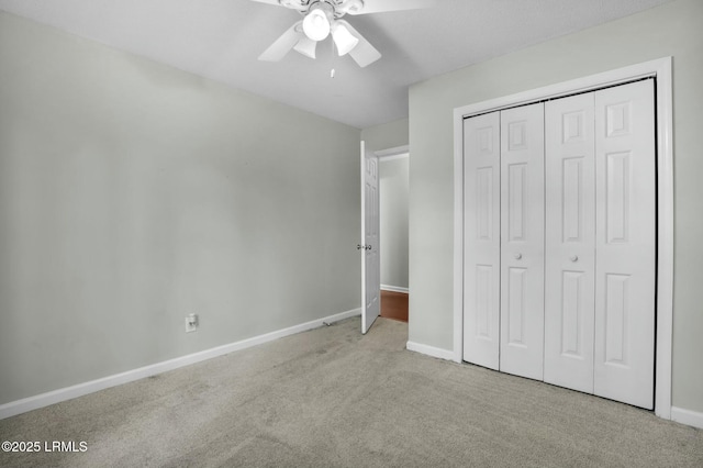 unfurnished bedroom featuring light carpet, ceiling fan, a closet, and baseboards