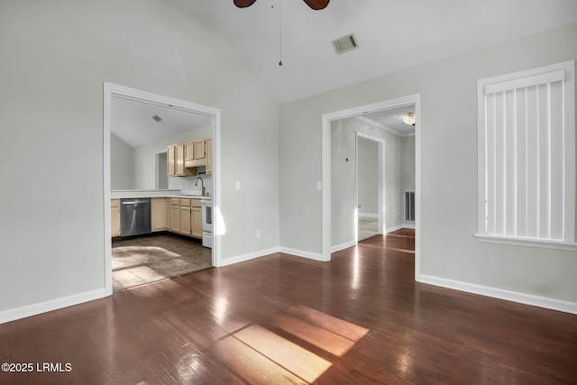 unfurnished living room with dark wood-style flooring, visible vents, a sink, and baseboards