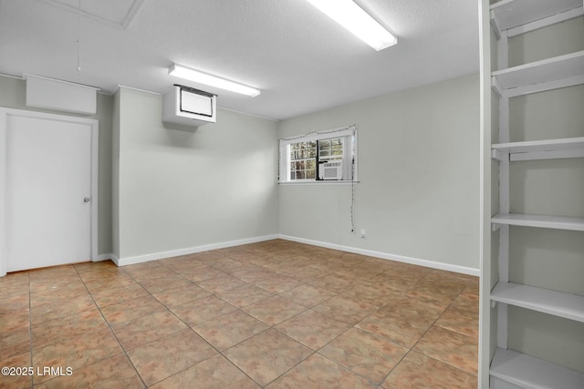 interior space featuring baseboards, attic access, built in features, and a textured ceiling