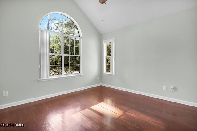 empty room featuring vaulted ceiling, ceiling fan, wood finished floors, and baseboards