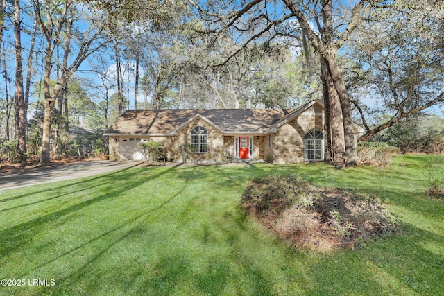 view of front facade with a front yard, stone siding, driveway, and an attached garage