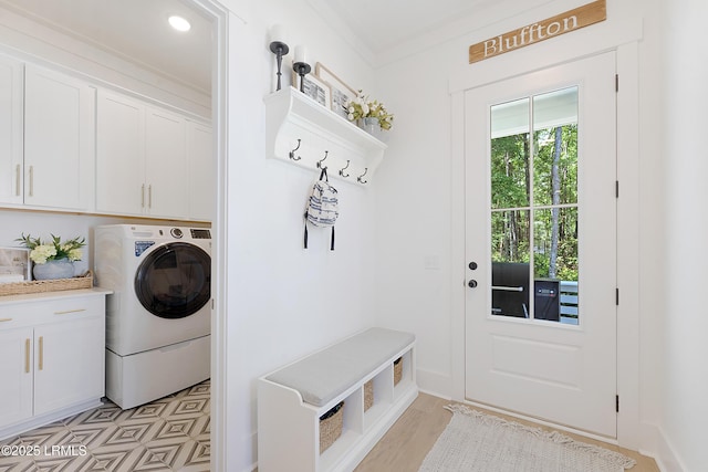 laundry area featuring crown molding, cabinet space, and washer / dryer