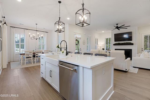 kitchen featuring plenty of natural light, a sink, an island with sink, and dishwasher