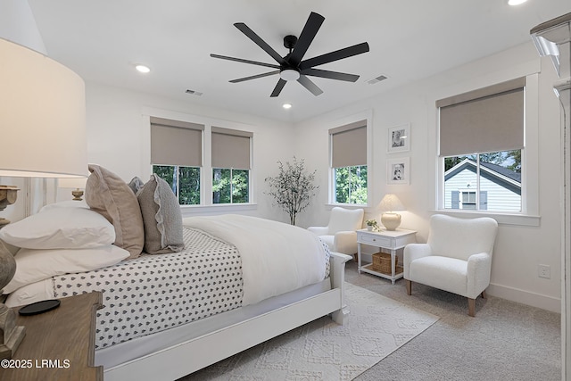 bedroom featuring visible vents, carpet, and multiple windows