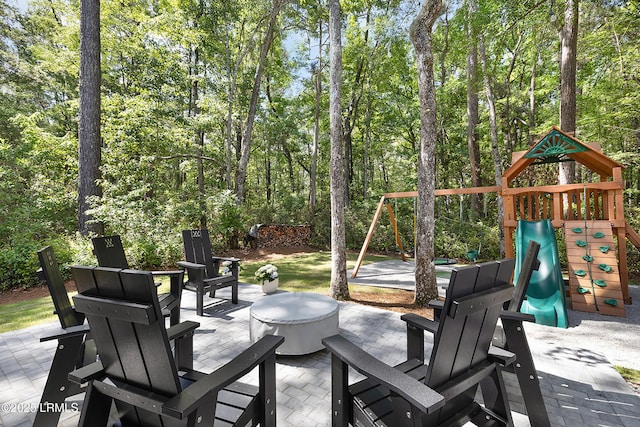 view of patio / terrace featuring a playground and an outdoor fire pit
