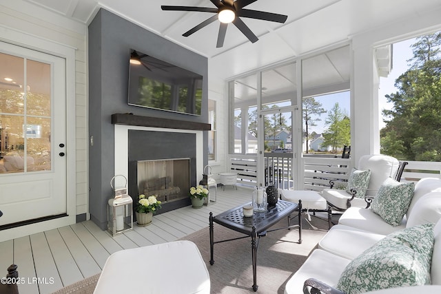 living room with a ceiling fan and a fireplace