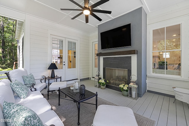 living room with french doors, a ceiling fan, hardwood / wood-style floors, and a fireplace