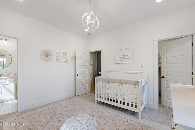 bedroom featuring baseboards, an inviting chandelier, and a crib