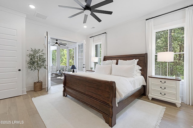 bedroom with access to exterior, multiple windows, and light wood-type flooring