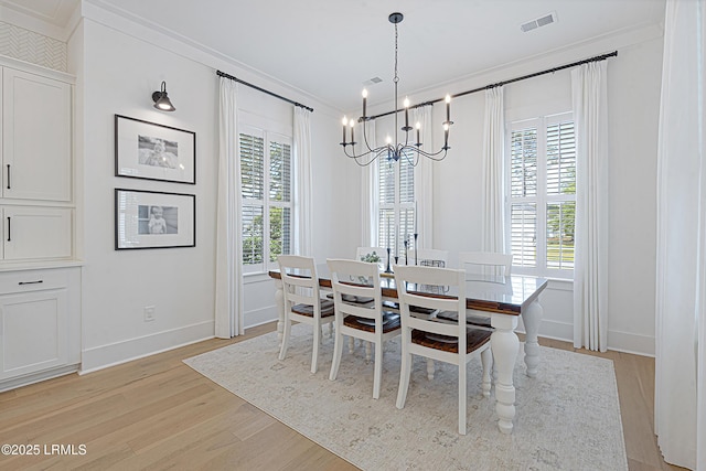 dining area featuring visible vents, ornamental molding, an inviting chandelier, baseboards, and light wood-type flooring
