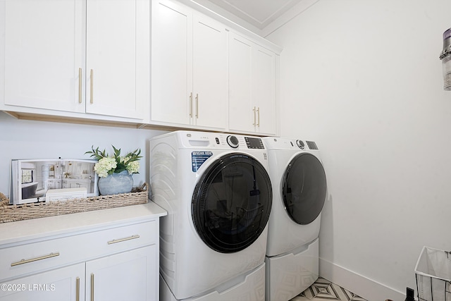 laundry area with baseboards, independent washer and dryer, and cabinet space