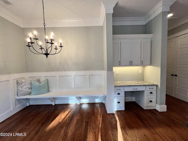 interior space with a notable chandelier, crown molding, built in desk, and dark hardwood / wood-style floors