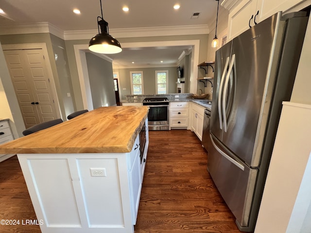 kitchen featuring white cabinets, a kitchen breakfast bar, hanging light fixtures, kitchen peninsula, and stainless steel appliances