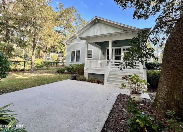 back of house featuring a yard, ceiling fan, and a porch