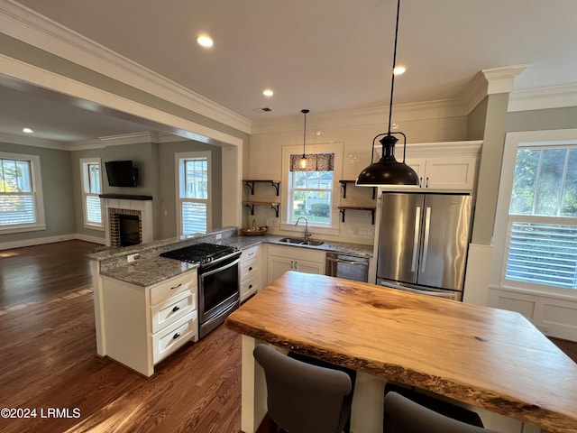 kitchen featuring sink, appliances with stainless steel finishes, white cabinetry, dark hardwood / wood-style floors, and light stone countertops