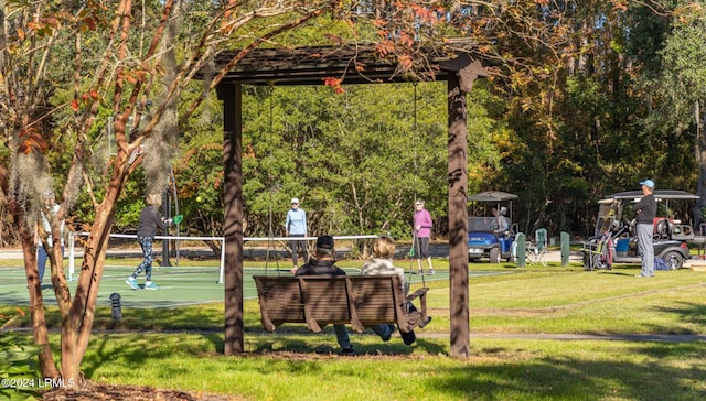 view of community with a lawn and basketball hoop