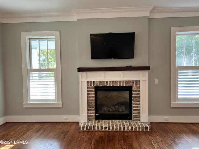 details with crown molding, a brick fireplace, and hardwood / wood-style flooring