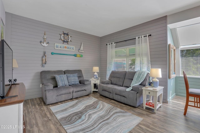 living room featuring hardwood / wood-style floors and wooden walls