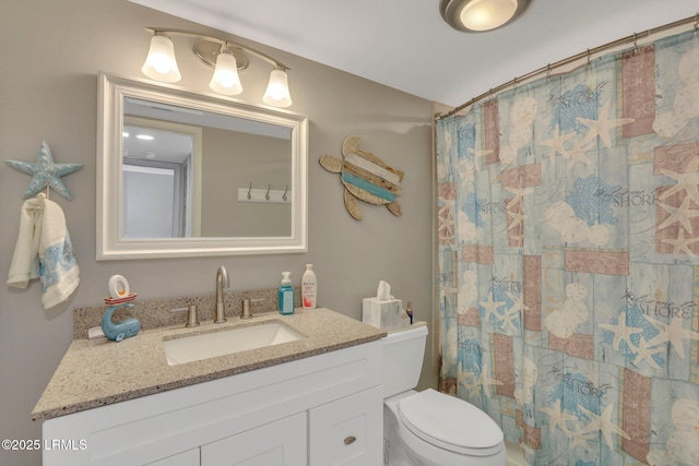 bathroom featuring vanity, curtained shower, and toilet