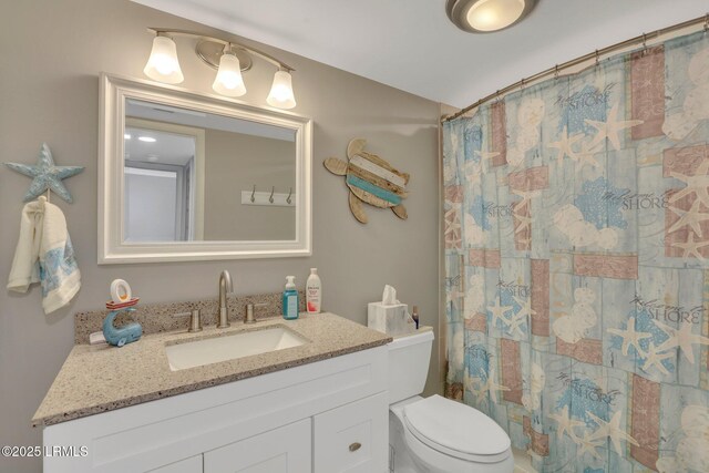 bathroom featuring vanity, curtained shower, and toilet