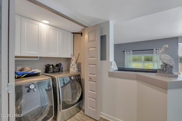 laundry area with light hardwood / wood-style flooring, washer and clothes dryer, and cabinets