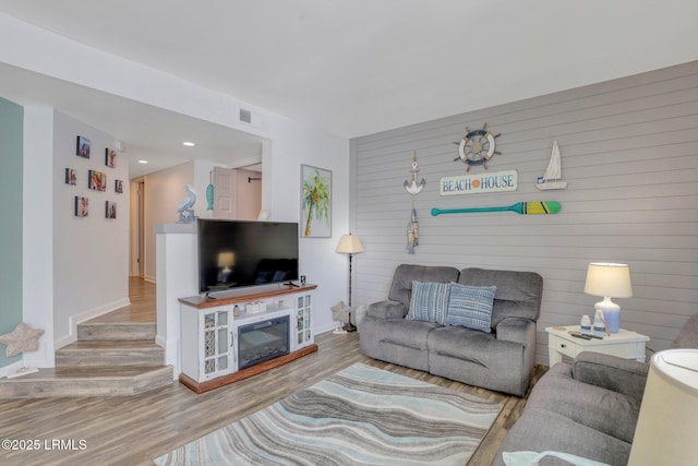 living room featuring hardwood / wood-style flooring and wooden walls